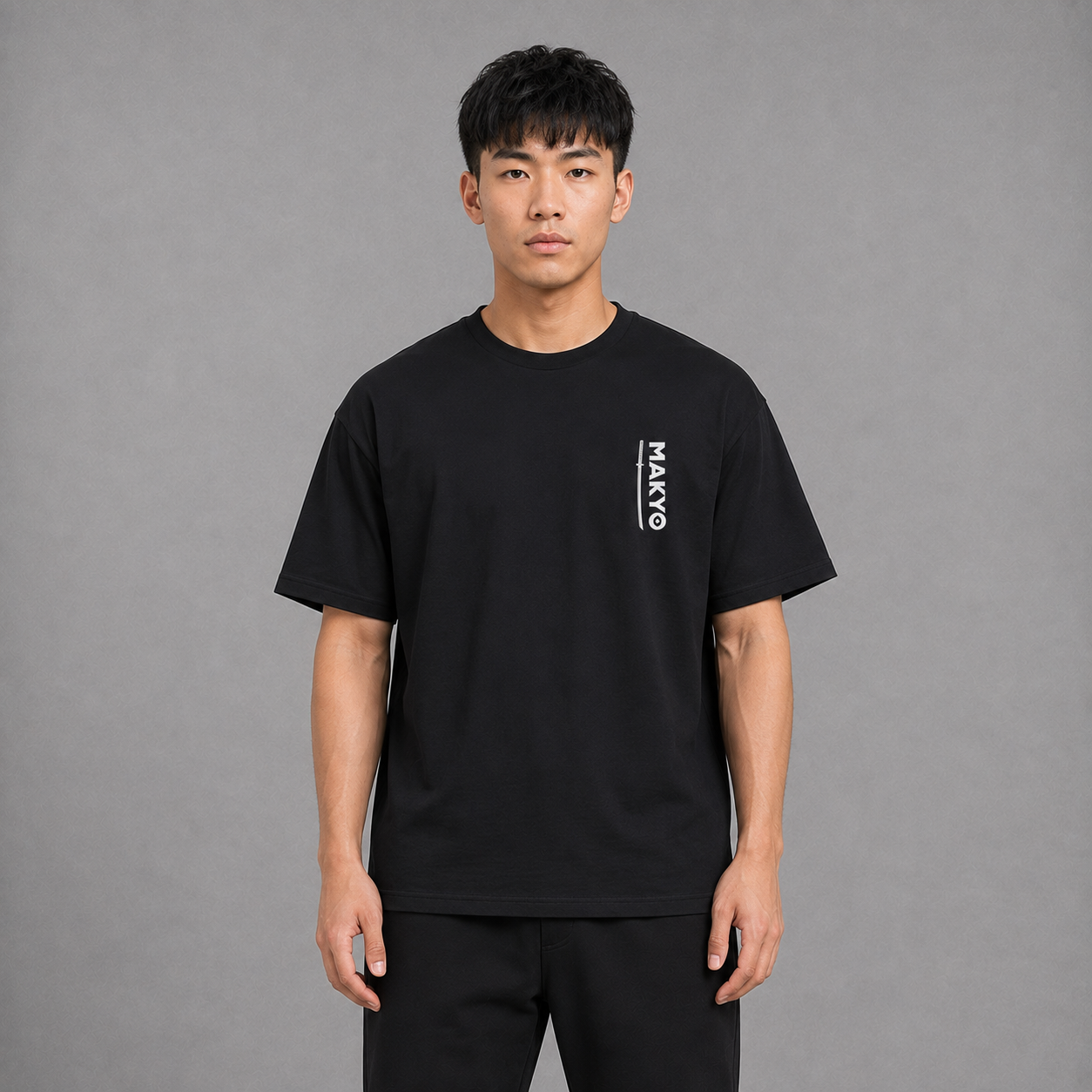 Front view of a model wearing the black Enter the Realm T-shirt with minimal chest graphic