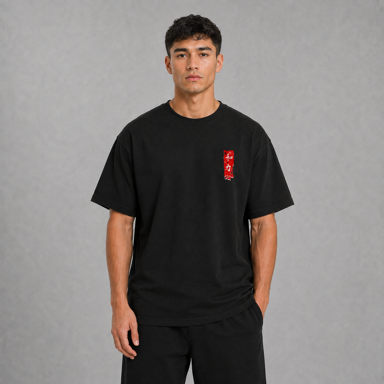Front view of a model wearing the black Koi Path T-shirt with minimal red chest graphic